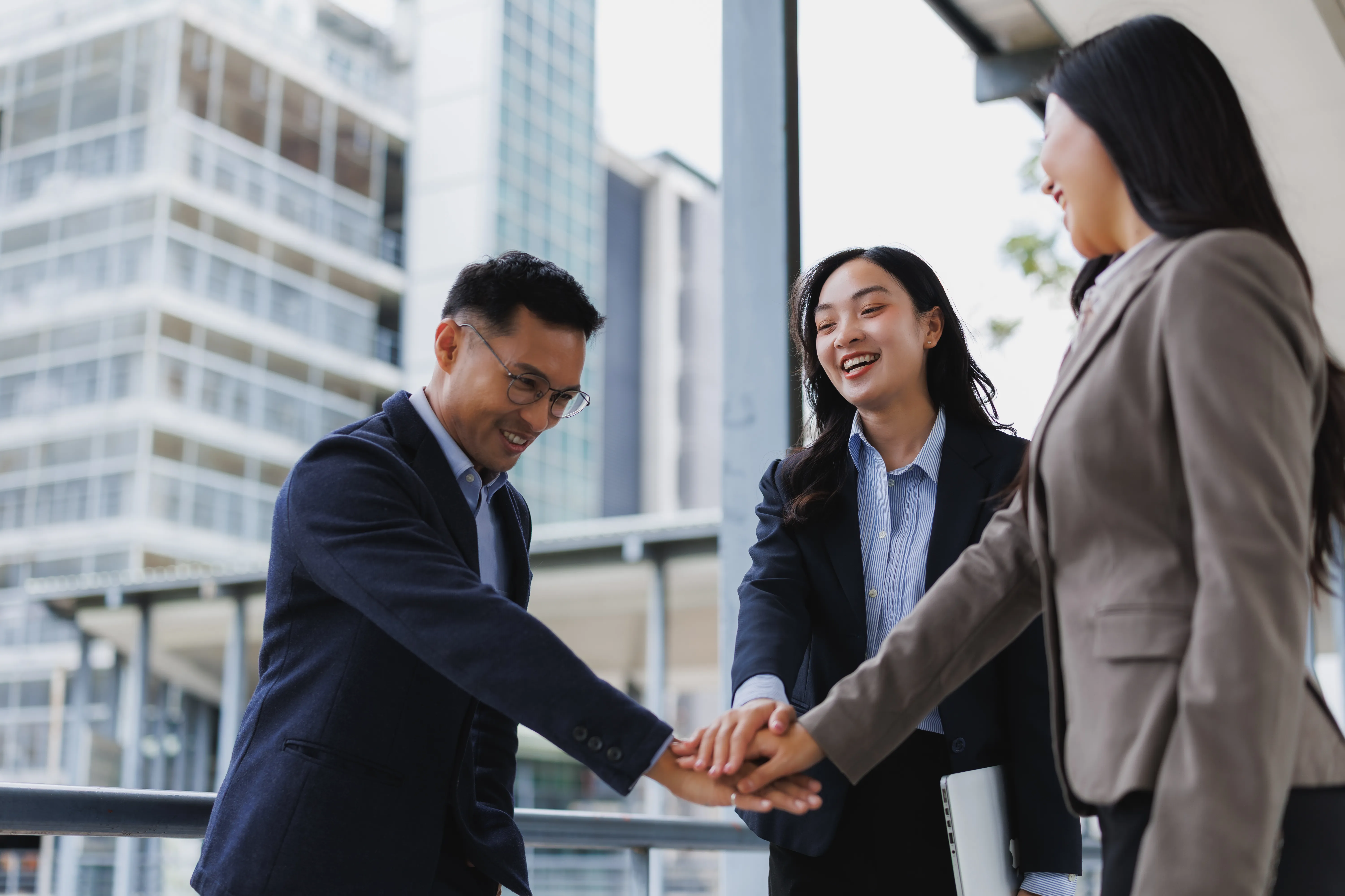 happy-business-team-joining-hands