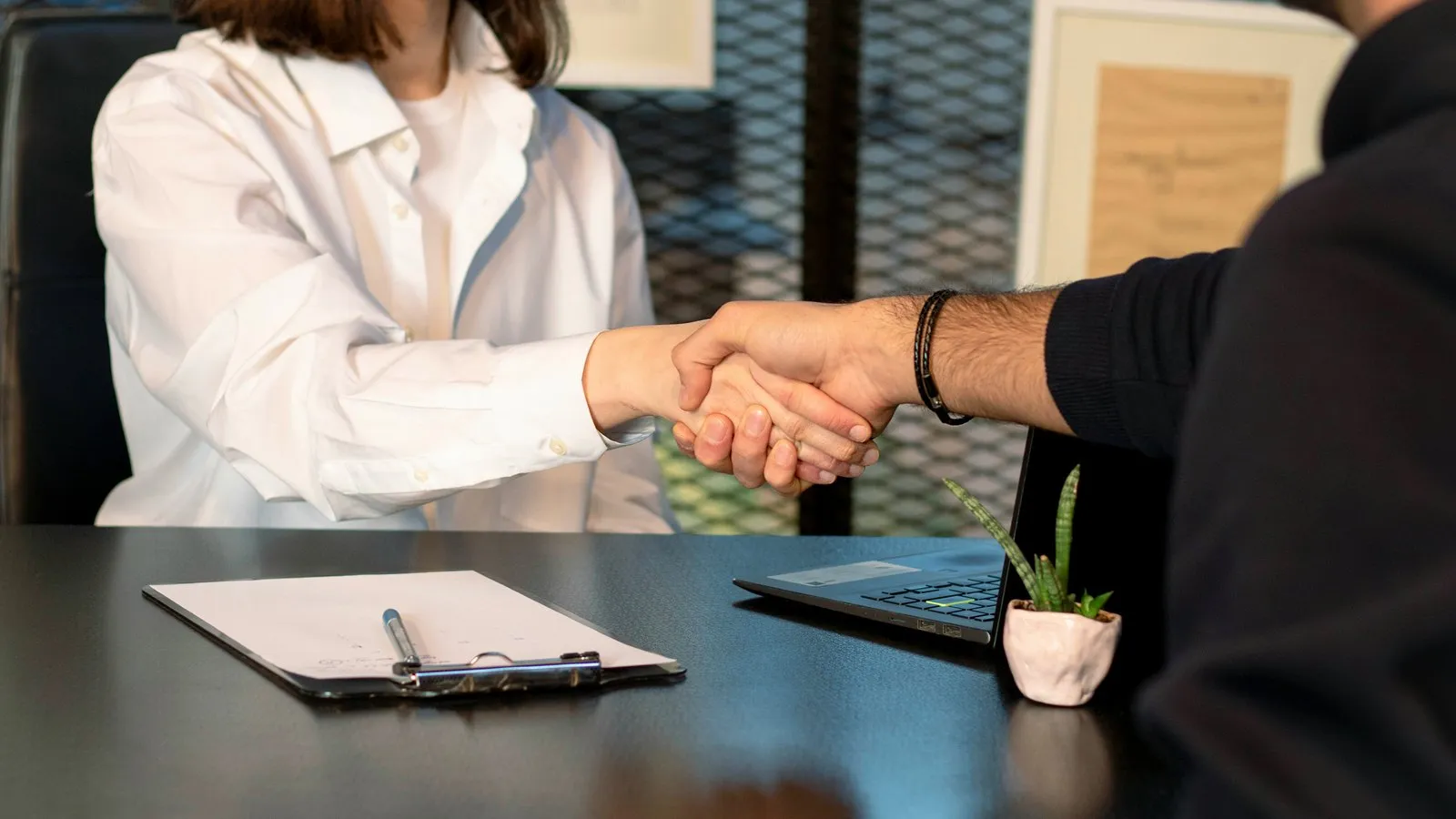 A supplier and a buyer agreeing terms across a desk