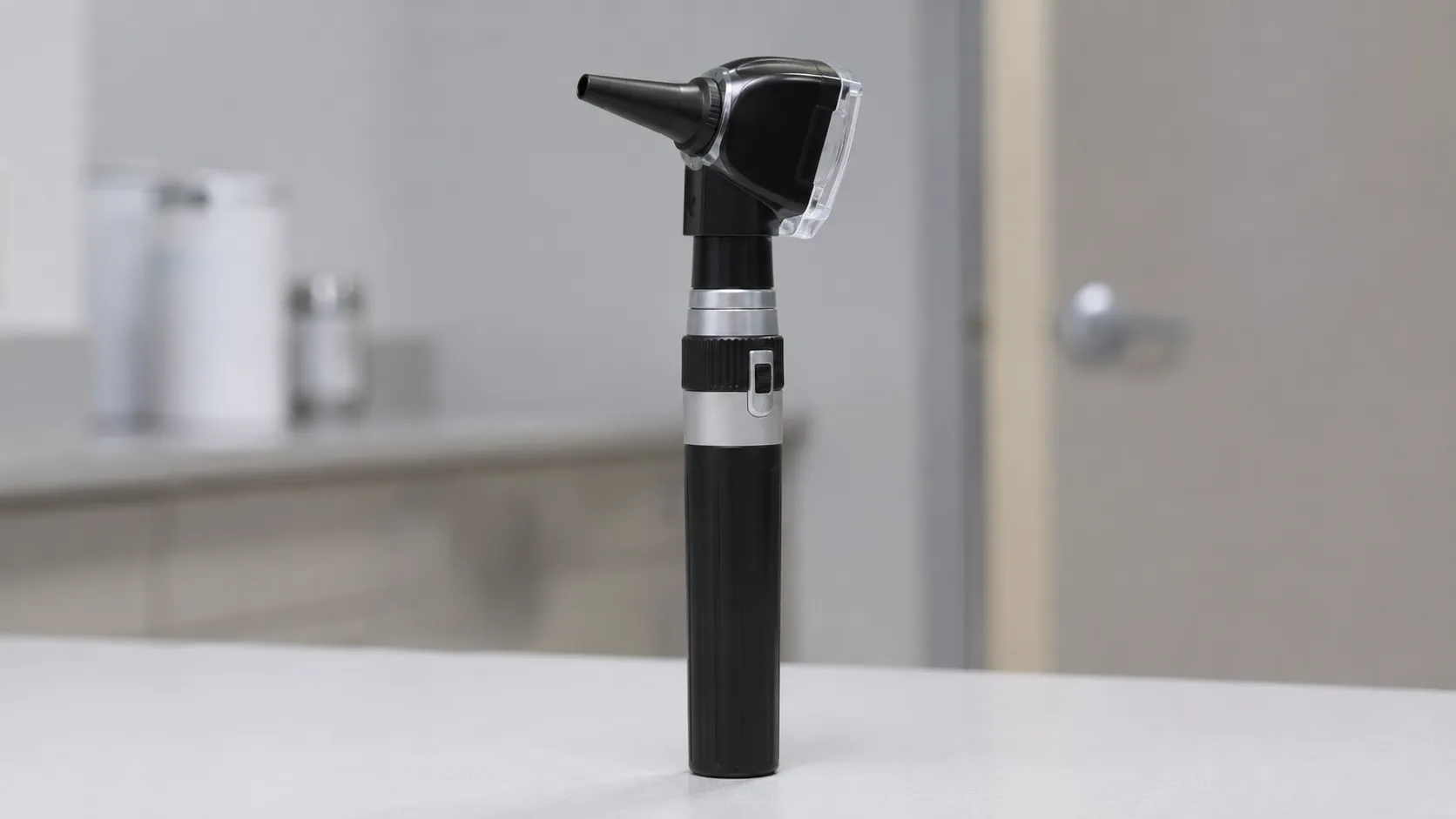 Clinician using a fibre-optic otoscope to examine a patient's ear canal and eardrum in an ENT clinic