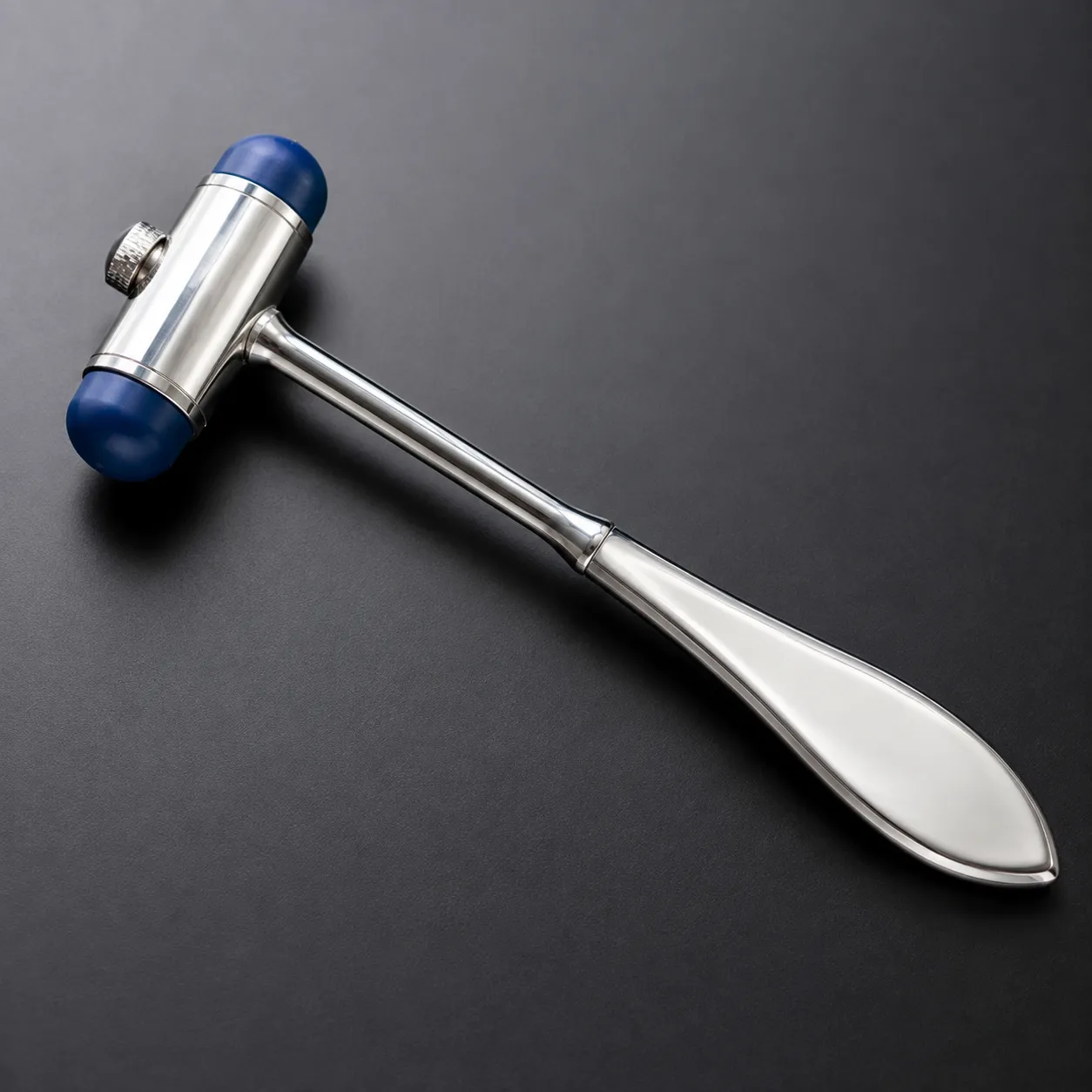 Clinician using a Queen Square reflex hammer to test a patient's knee tendon reflex during a neurolo