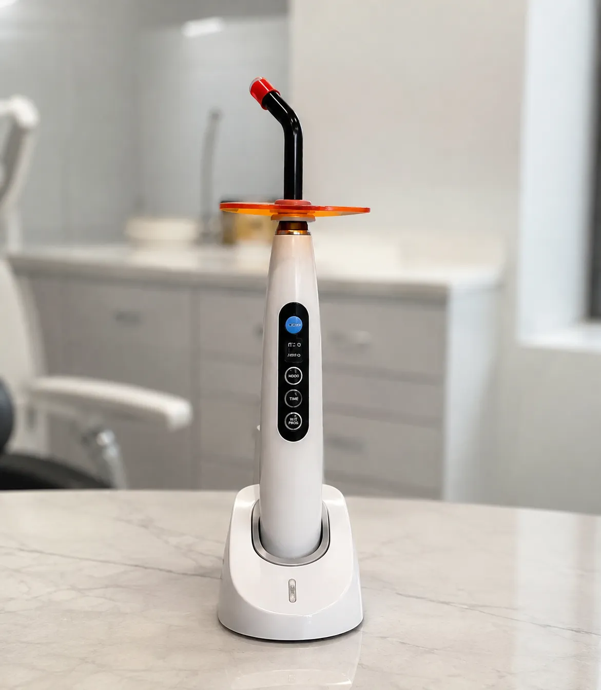Cordless LED dental curing light with tip positioned over a composite restoration