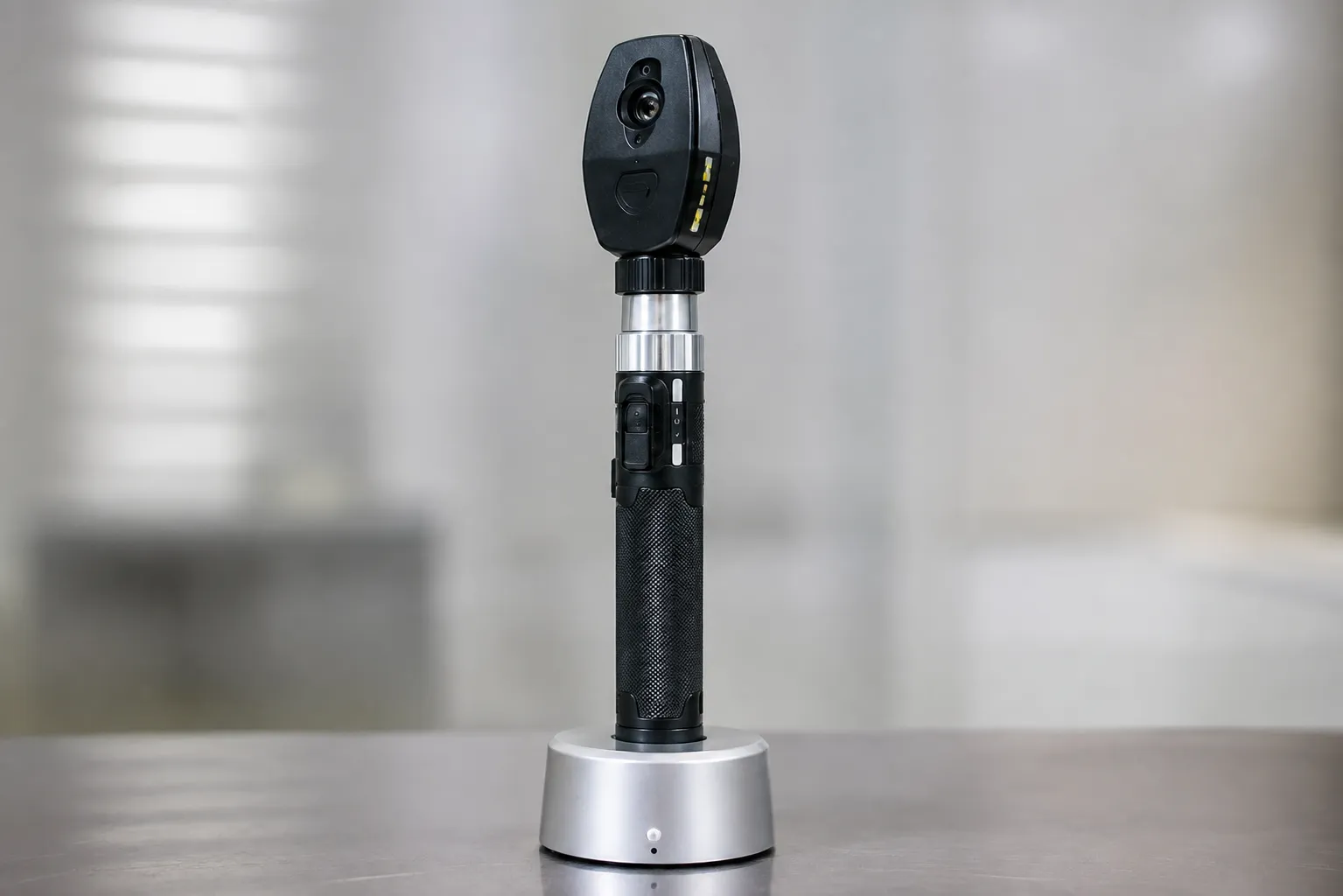 Direct ophthalmoscope with rechargeable handle being used for a fundus examination in a clinic