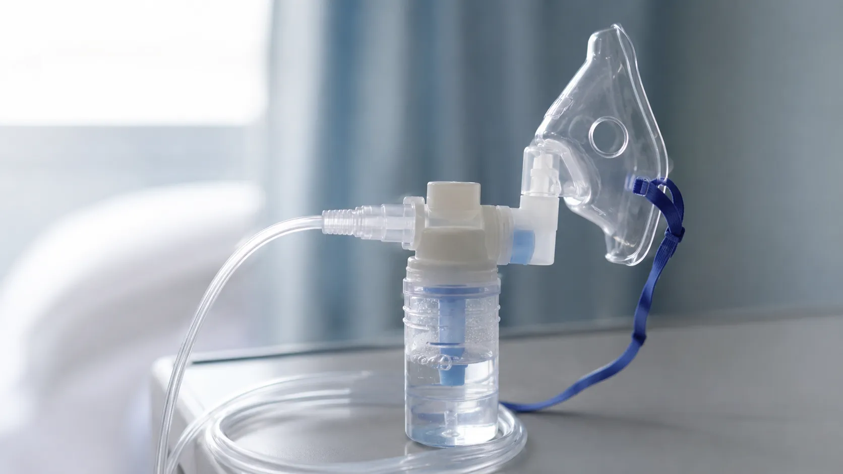 Large-volume nebuliser with reservoir driven by oxygen delivering continuous aerosol to a monitored 