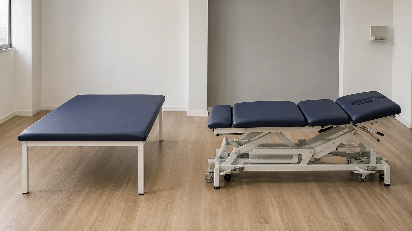 Electric two-section physiotherapy treatment plinth with firm padded top in a rehabilitation clinic