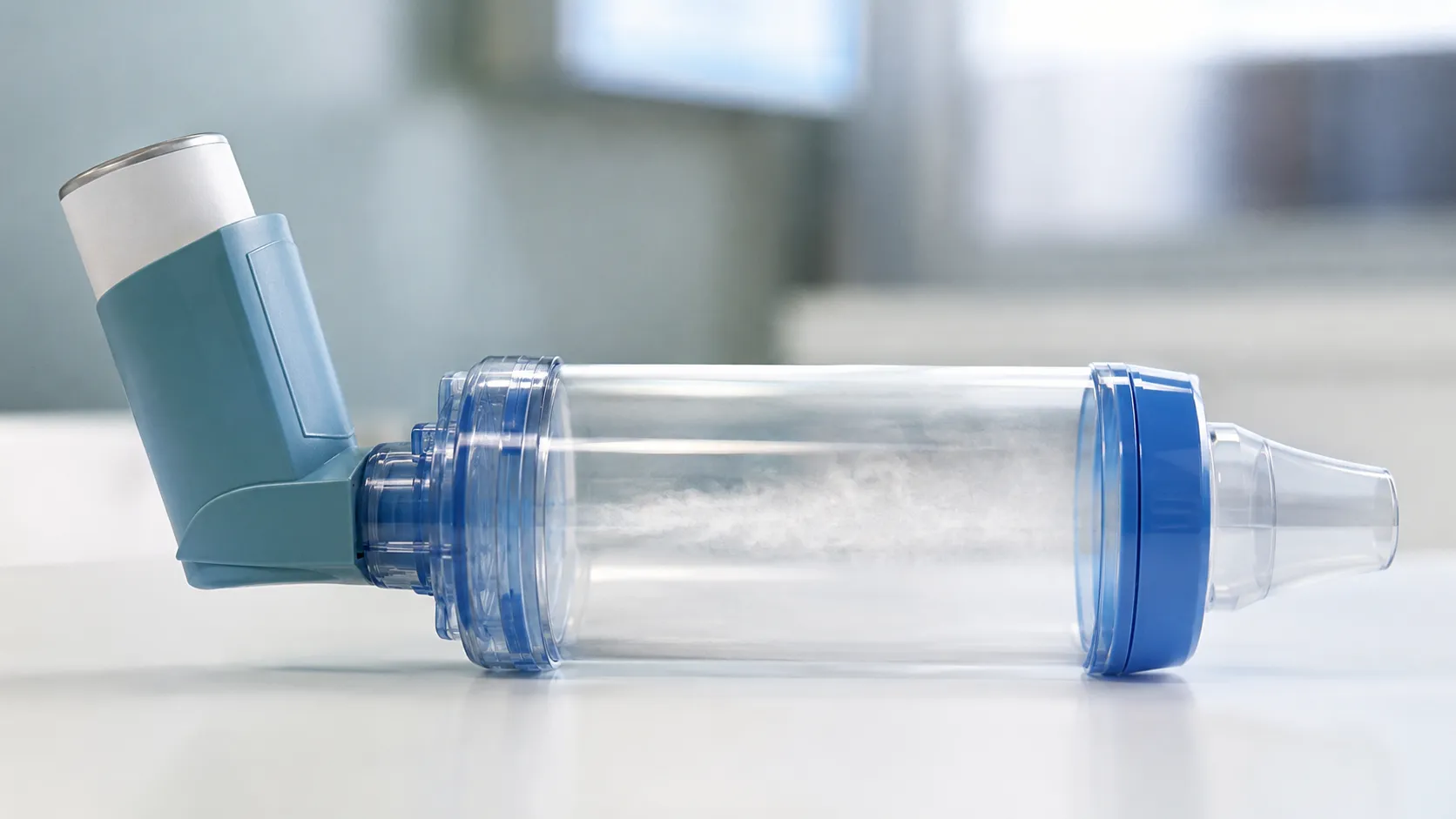 Valved holding chamber spacer with a paediatric face mask attached to a metered dose inhaler on a cl